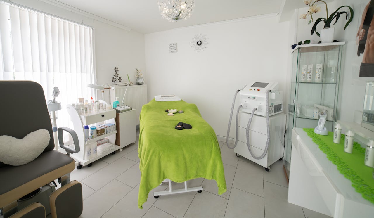 Bright and cozy clinic room featuring a comfortable treatment bed and modern equipment.