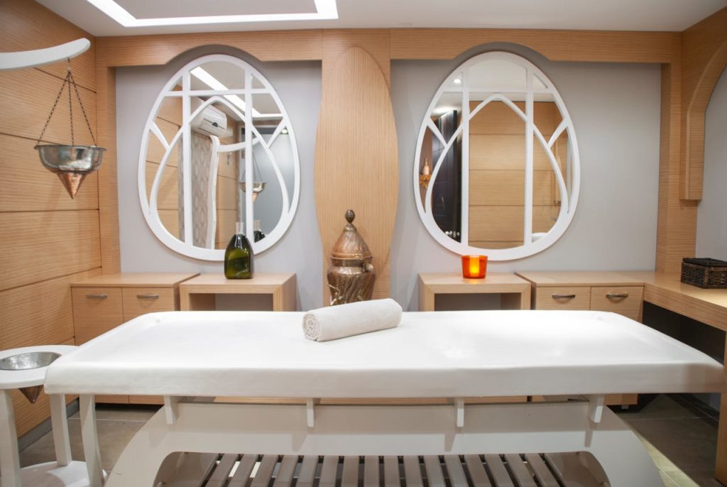 Elegant spa interior featuring a massage table and artistic mirrors, creating a relaxing atmosphere.